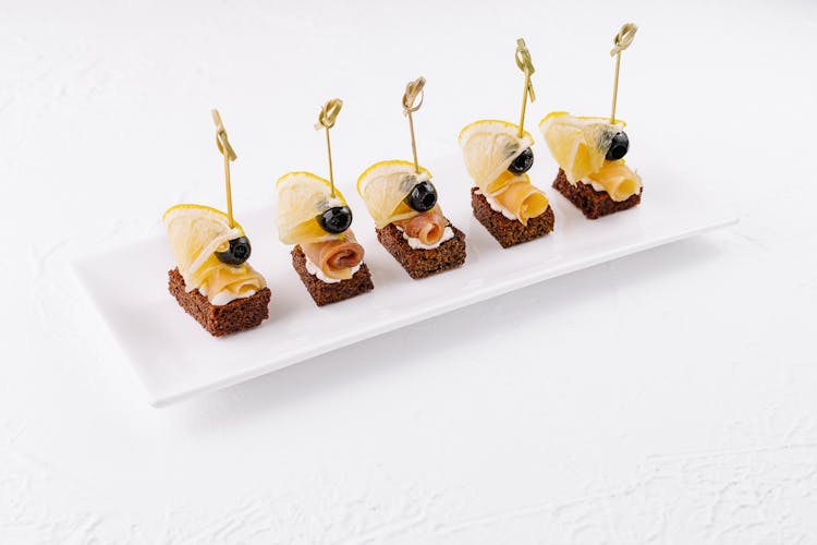 Canapes with buko cheese, escolar fish on toast with olives and lemon
